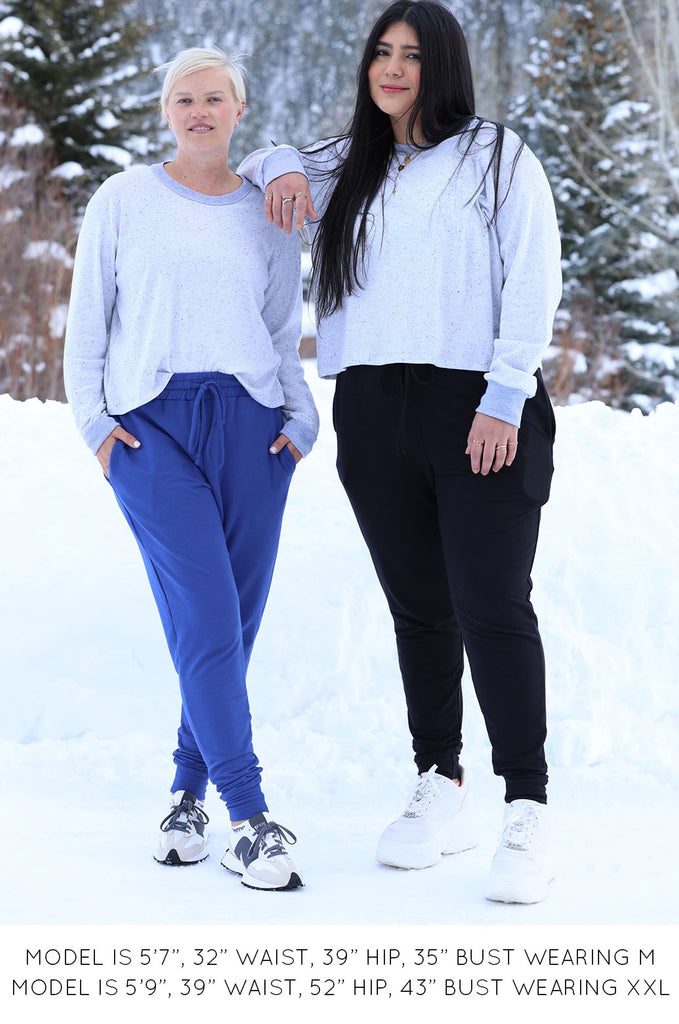 Two models wearing grey long sleeve tops by Miakoda. 