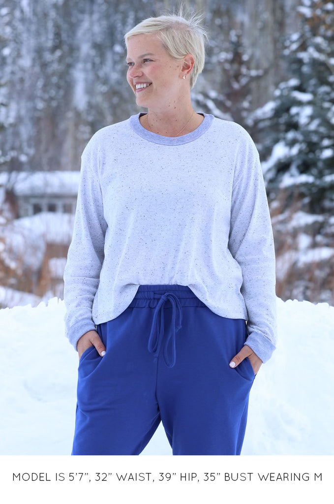 Model wearing grey long sleeve top by Miakado. 