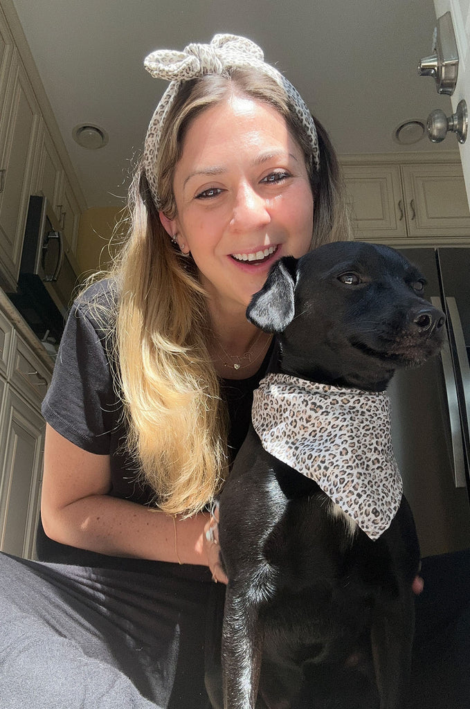 Woman wearing leopard print headband and dog wearing matching leopard print bandana by Miakoda. 