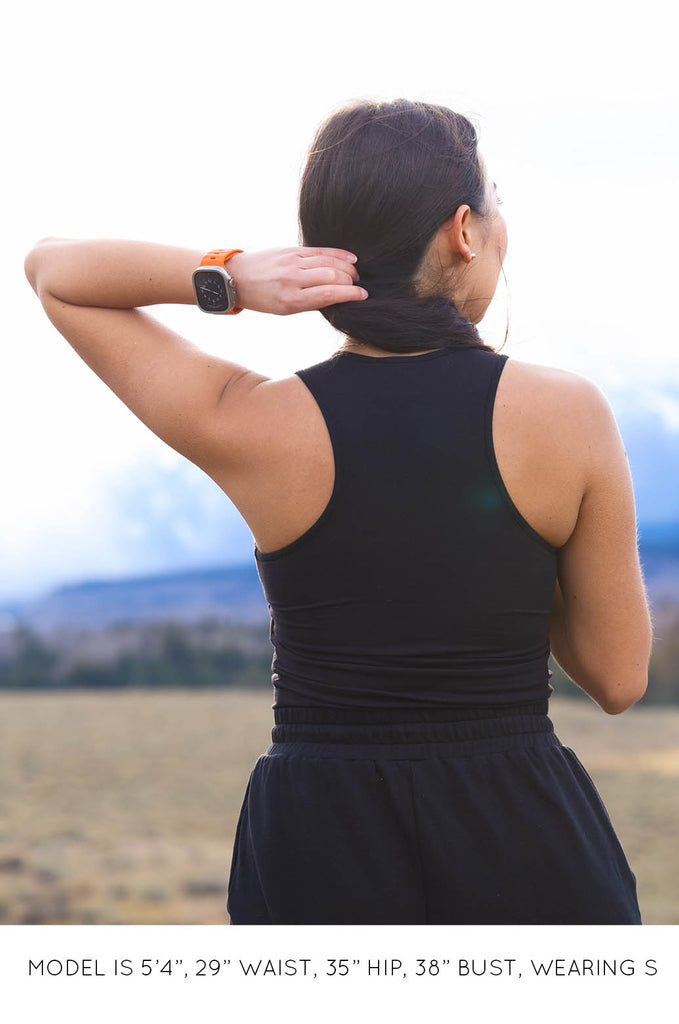 Back view of model wearing black Racer Tank by Miakoda. 