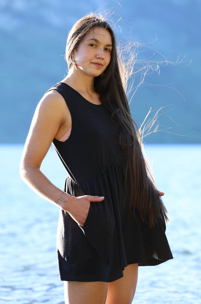 Model in front of lake wearing black Miakoda Summer Romper. 