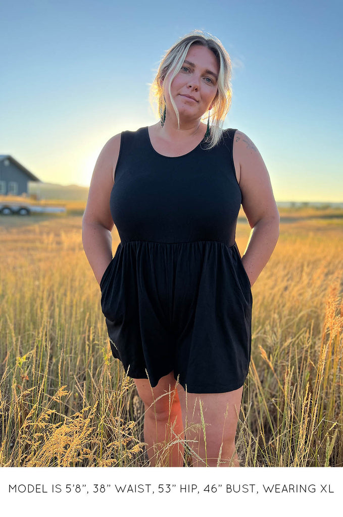 Model in field wearing black Summer Romper by Miakoda. 