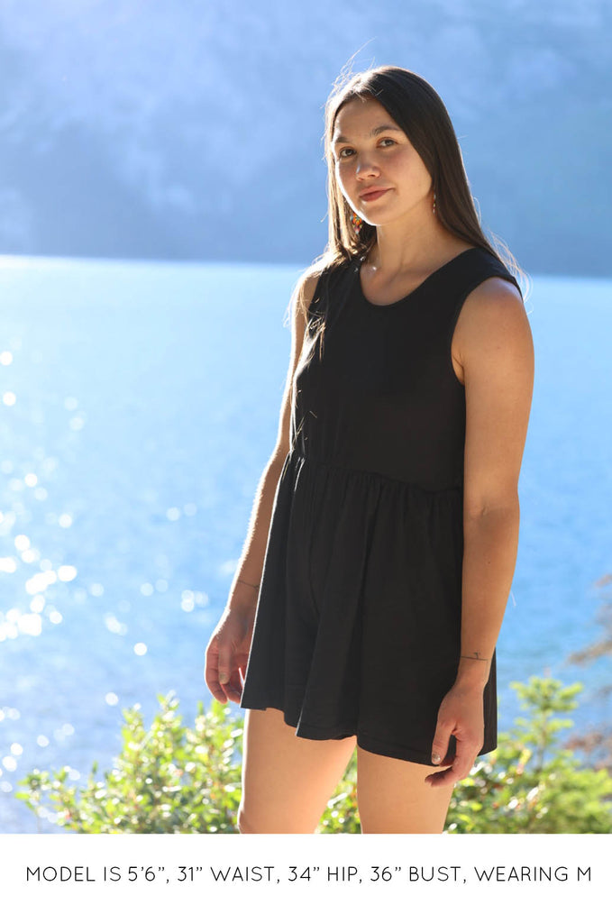 Model by lake wearing black Summer Romper by Miakoda. 