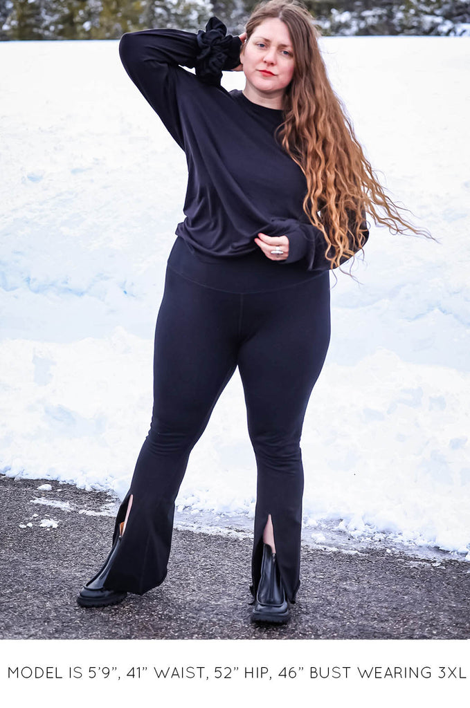 Model with snowy background wearing black Sweater and Split Leggings by Miakoda. 