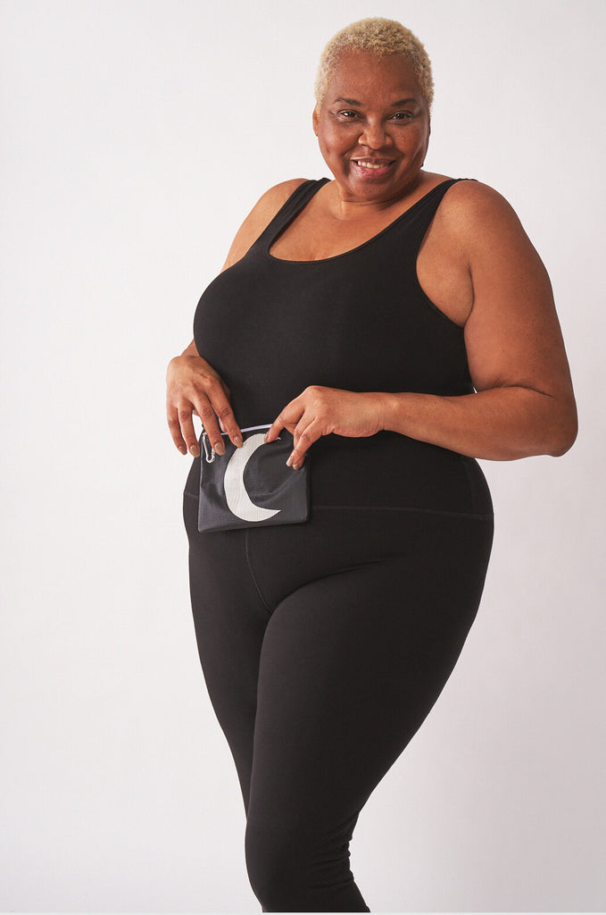 Model holding black RMG x MIAKODA Mini Moon Pouch with white moon. 