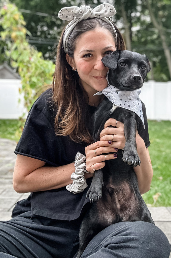 Woman wearing grey print headband with dog with matching bandana by Miakoda. 