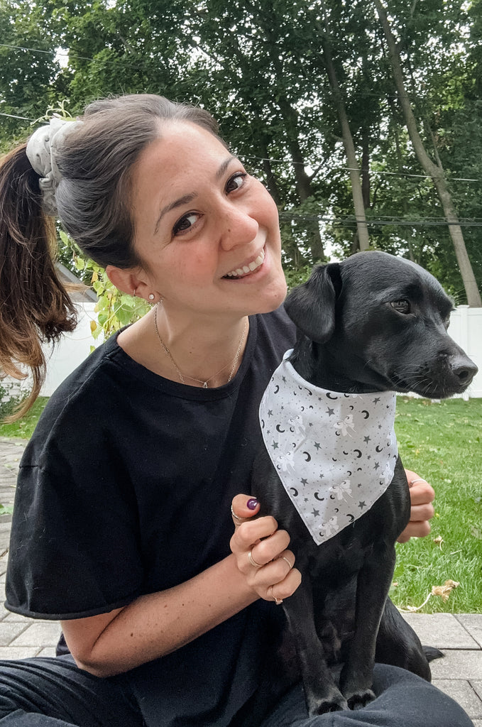 Woman with dog wearing grey print bandana by Miakoda. 