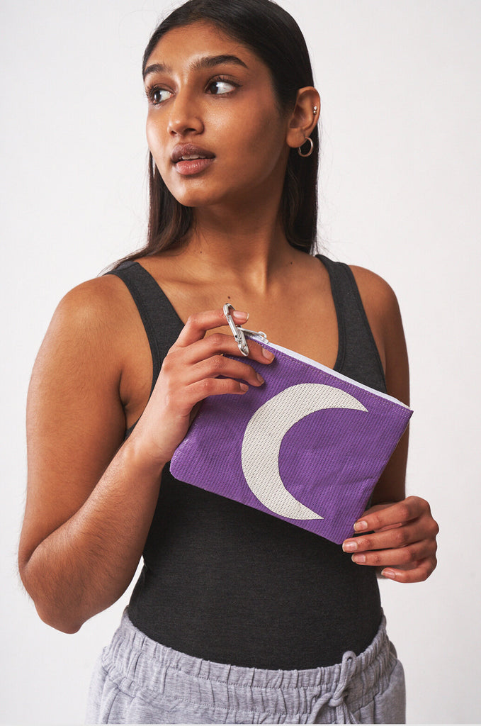 Model holding purple RMG x MIAKODA Mini Moon Pouch with white moon. 